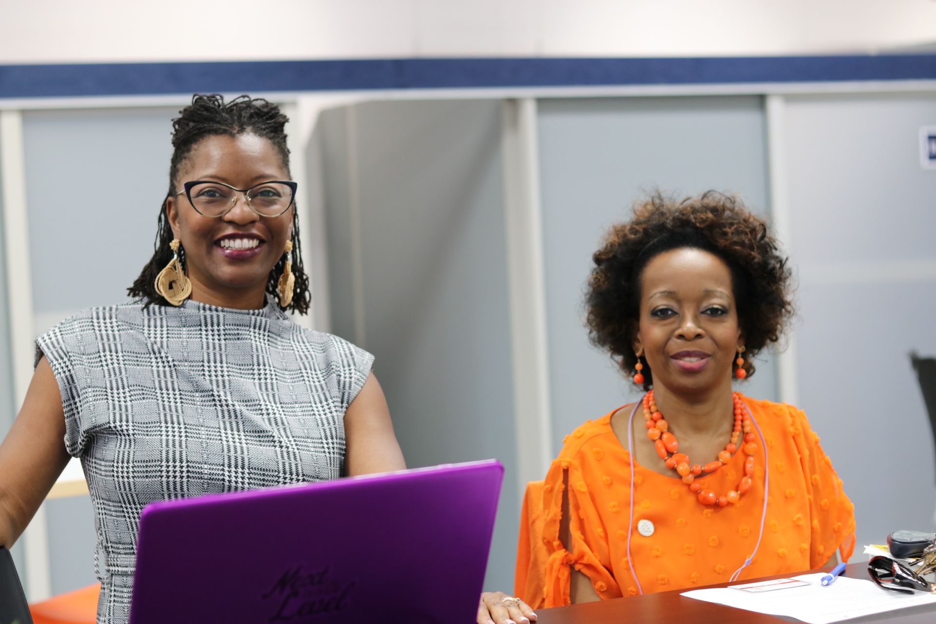 Two attendees working together on a laptop