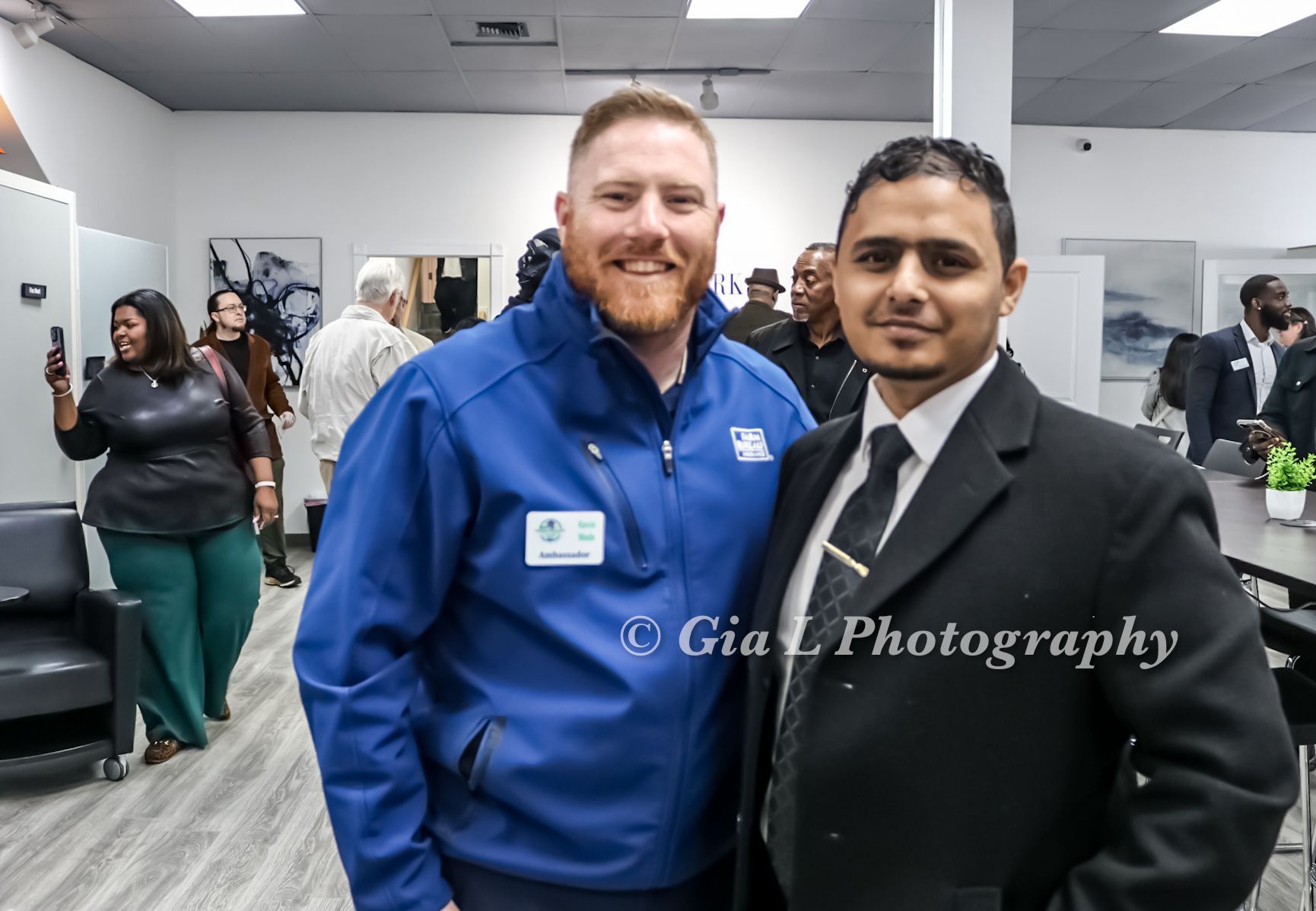 Two guests posing for a ribbon cutting photo