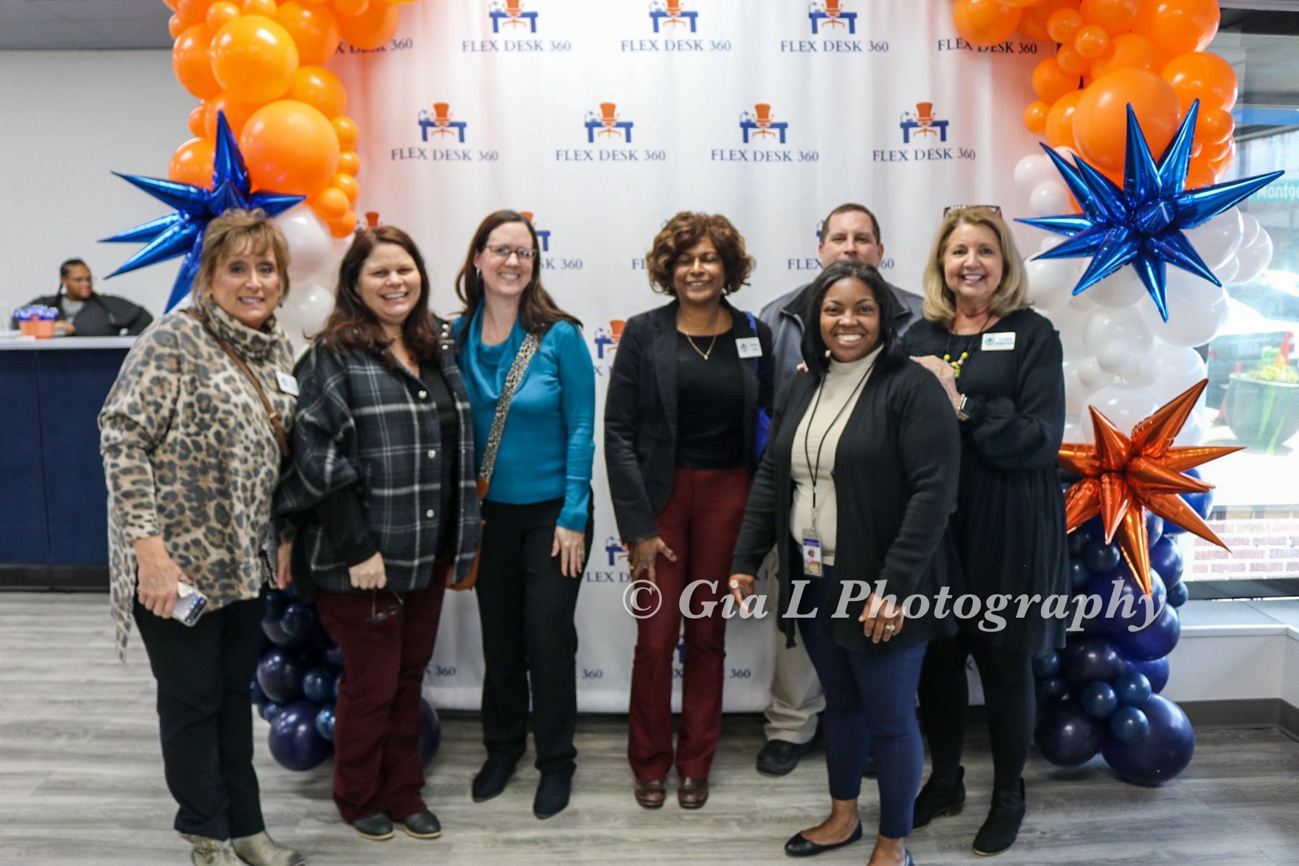 Group posing in front of ribbon cutting balloons